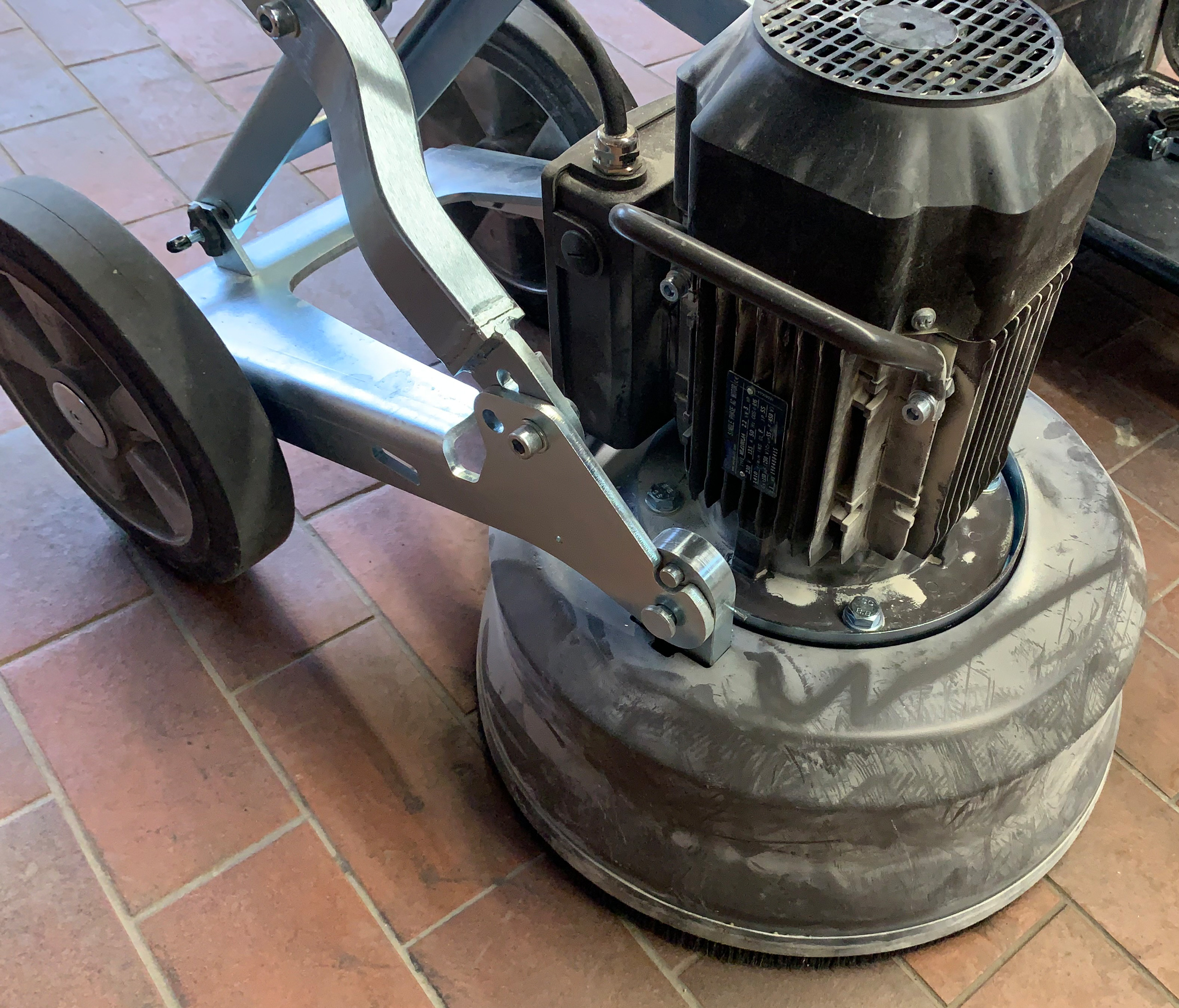 Detailansicht der Husqvarna PG 450 Bodenschleifmaschine mit Motor und Schleifkopf auf Fliesenboden.