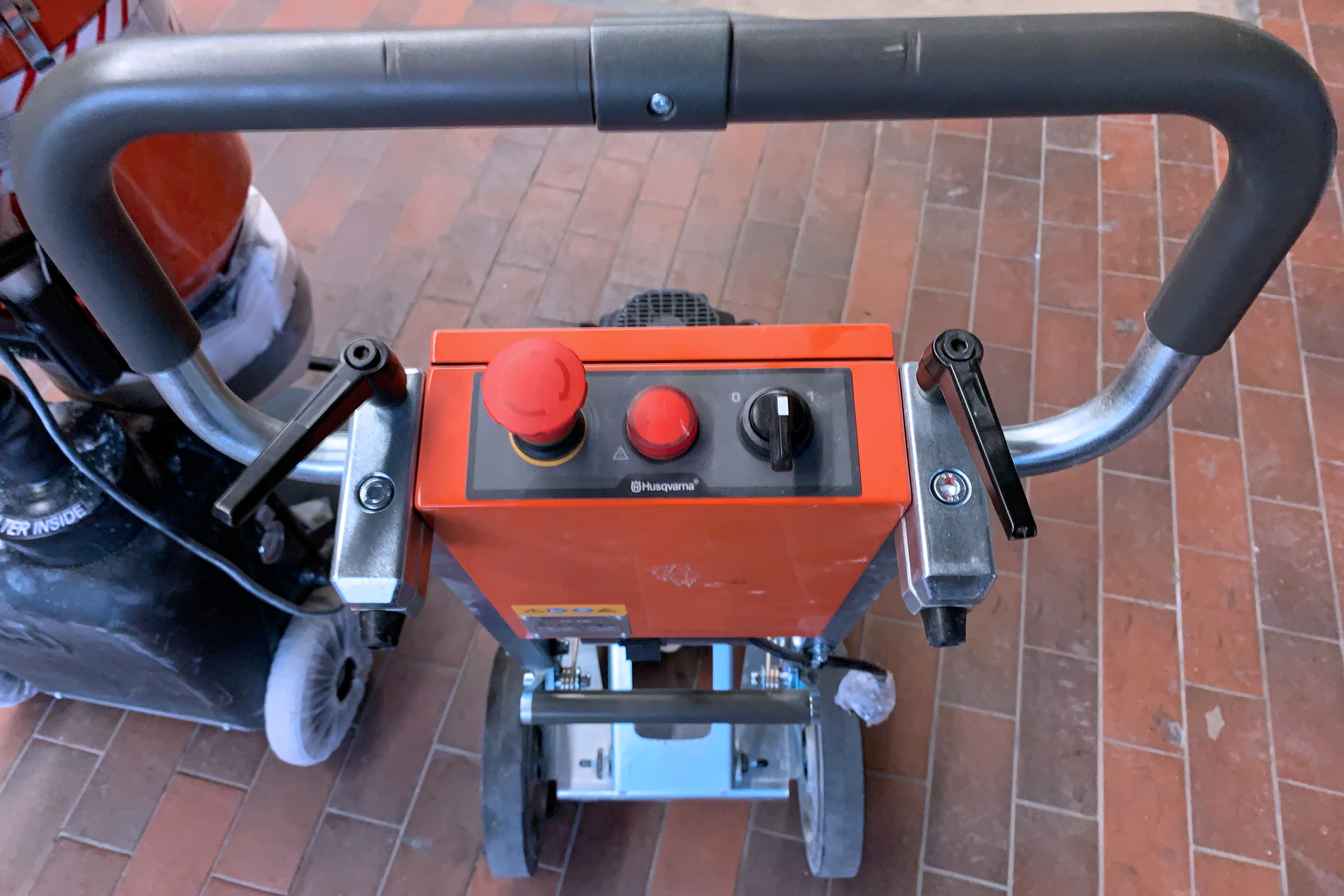 Bedienelemente der Husqvarna PG 450 Bodenschleifmaschine mit roten Knöpfen und Schalter, Aufsicht