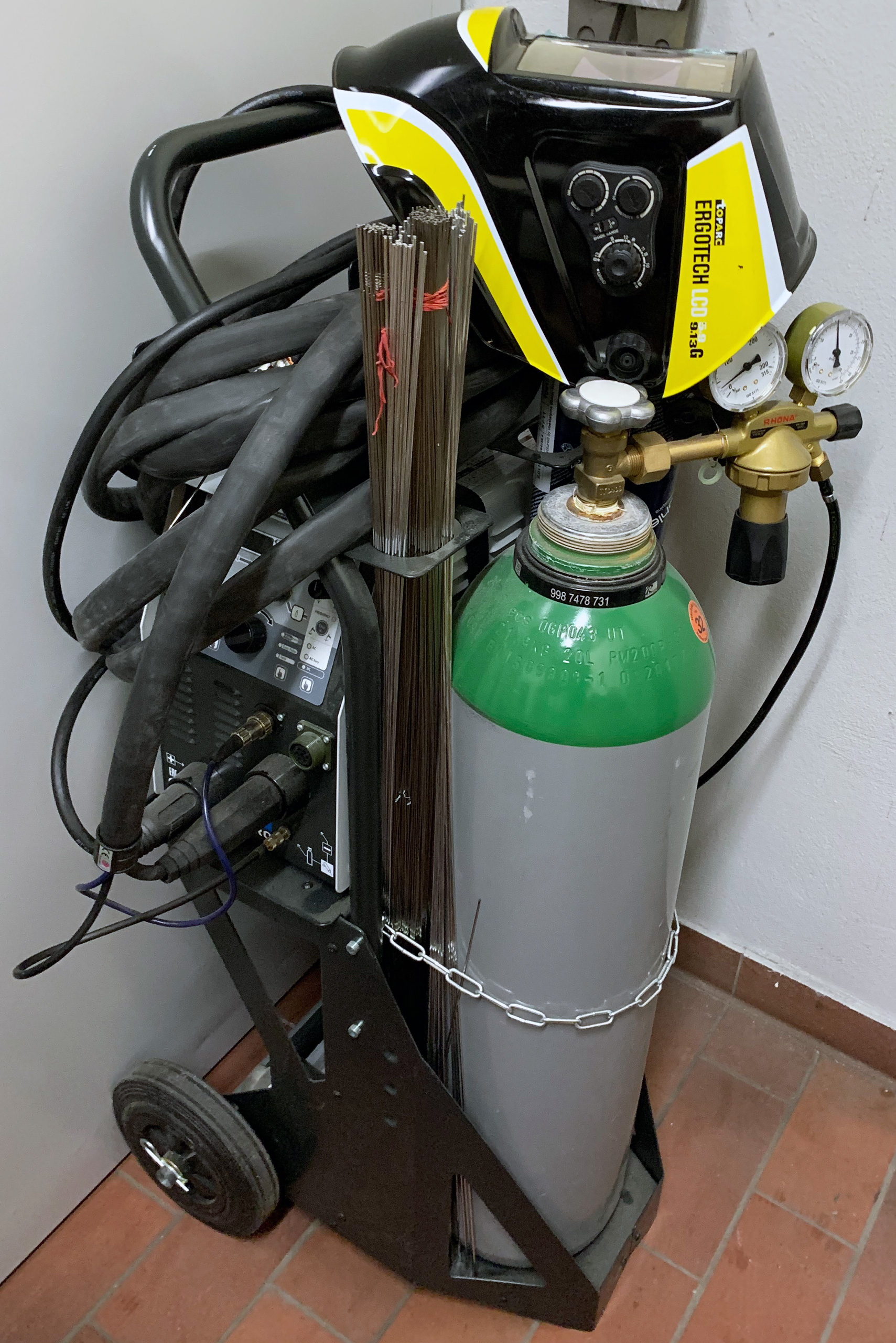 Detailansicht des IMS TIG 200A WIG Schweißgeräts mit Gasflasche, Schweißdraht und Schweißhelm